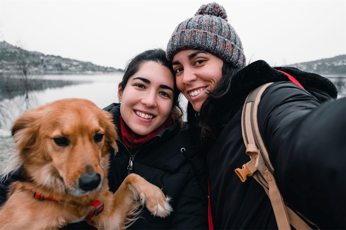 two sisters and their dog enjoying winter
